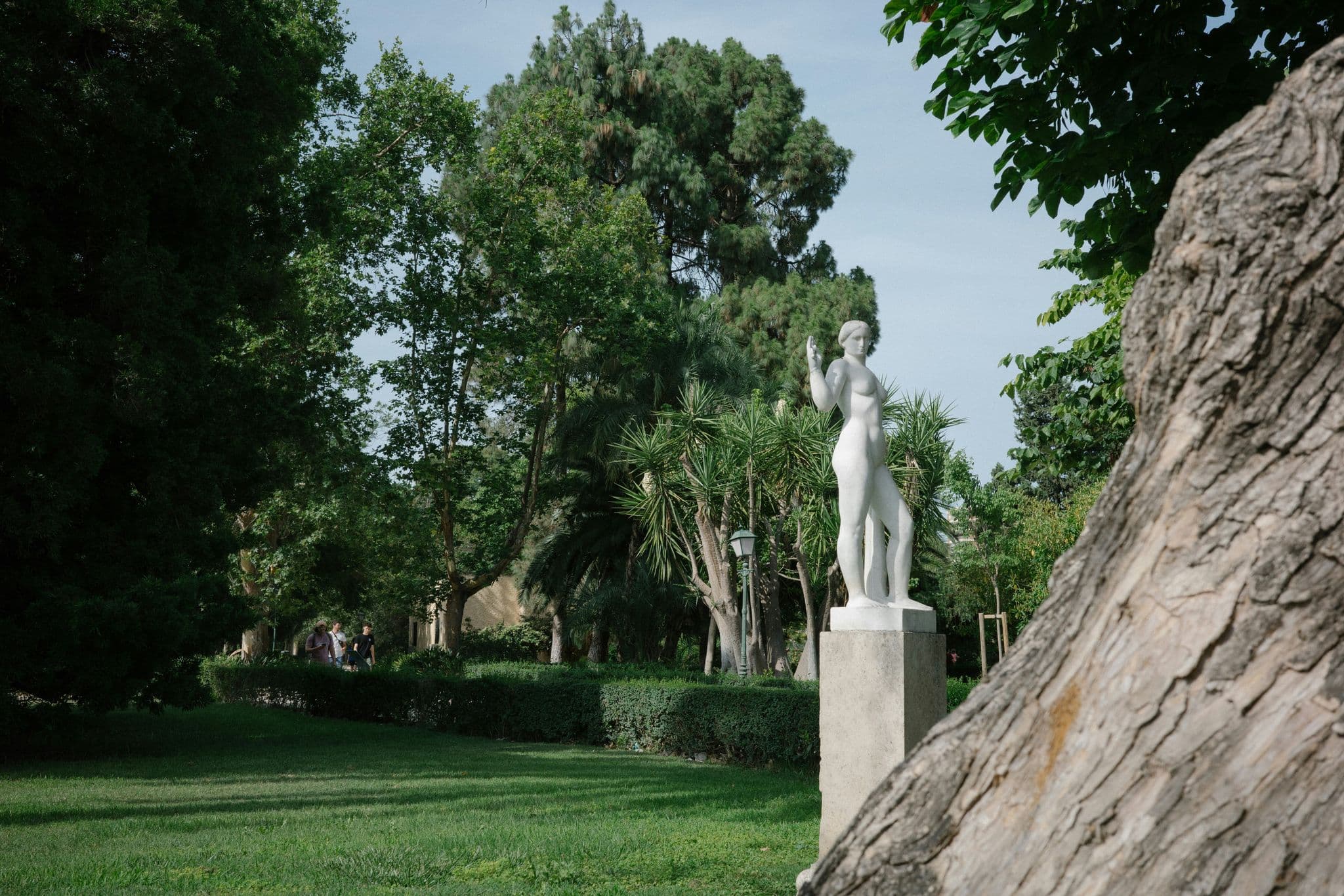 A statue of a woman standing next to a large rock